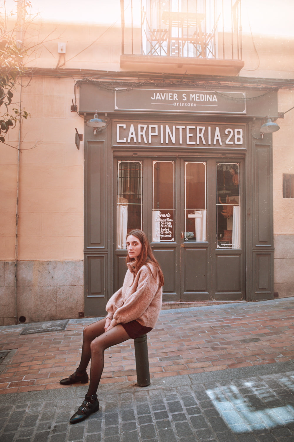 Woman sitting in front of a building in Madrid